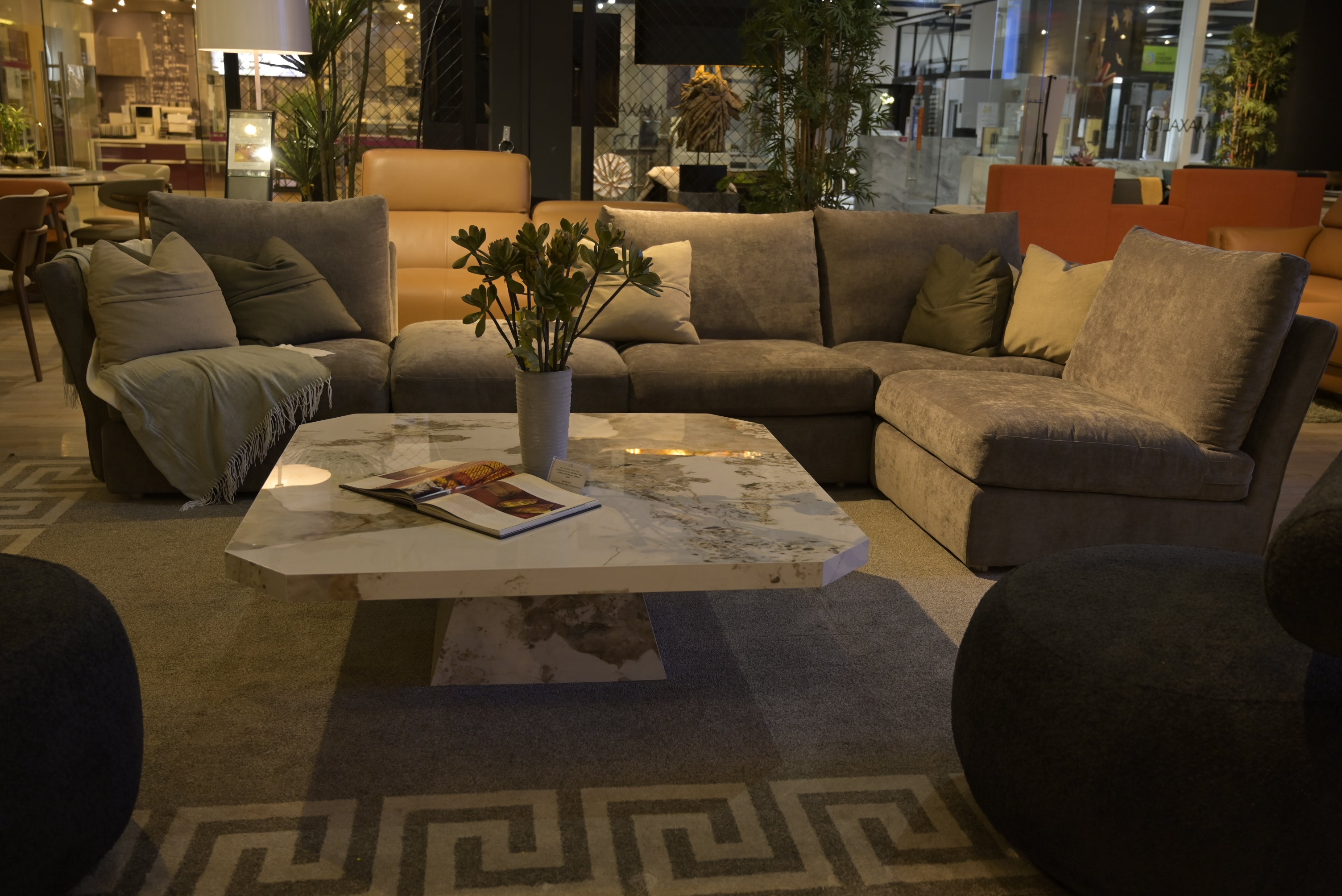 Living room with a sectional sofa, coffee table, and decorative items.