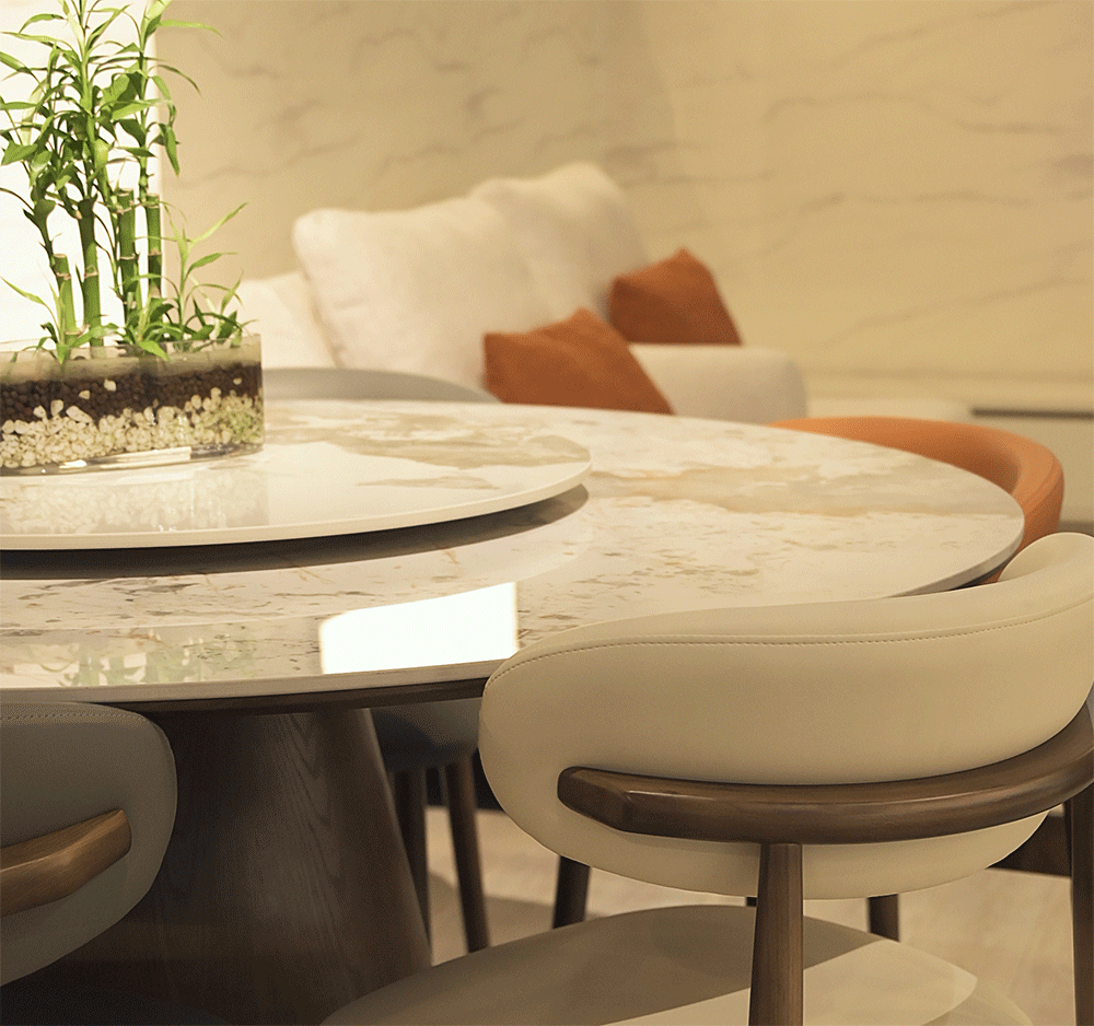Round marble dining table with chairs in a modern living room setting.