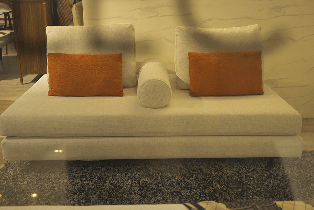 White sofa with orange cushions in a room setting